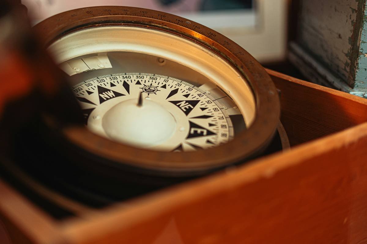Chart comparing authentic vintage compass types: marine binnacle, pocket surveyor's, and dry-card desk models with key identifying features