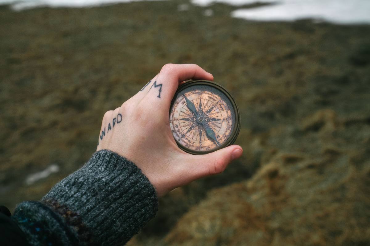 Side-by-side comparison: authentic brass home compass with working needle vs. cheap plastic decorative compass with fixed needle