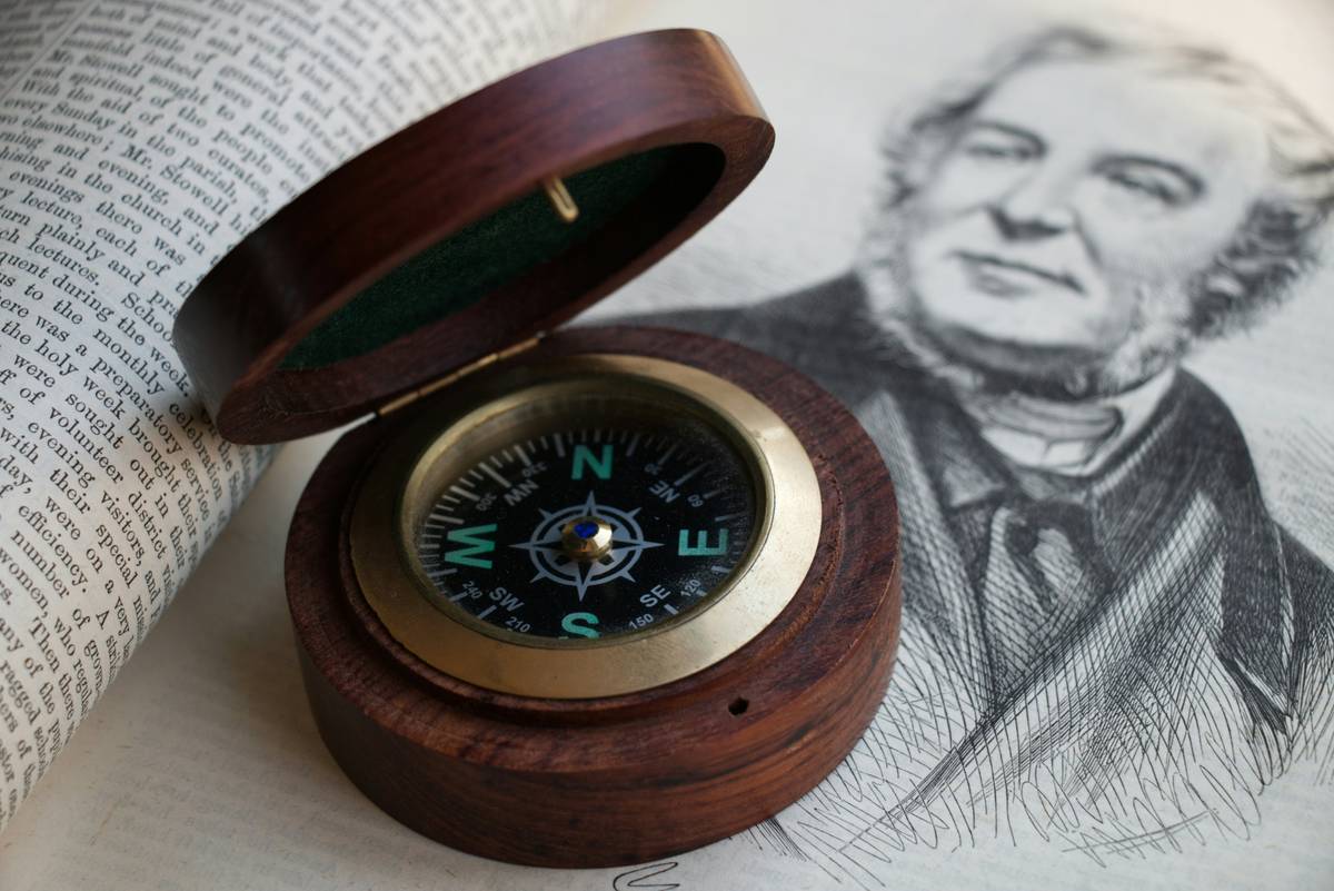 Infographic comparing antique brass compasses, modern minimalist wall compasses, and desktop decorative compasses with key features and best uses
